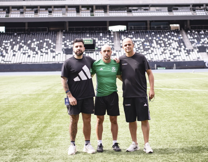 Julio with two of the adults who travel with the group, on the pitch at a Rio stadium