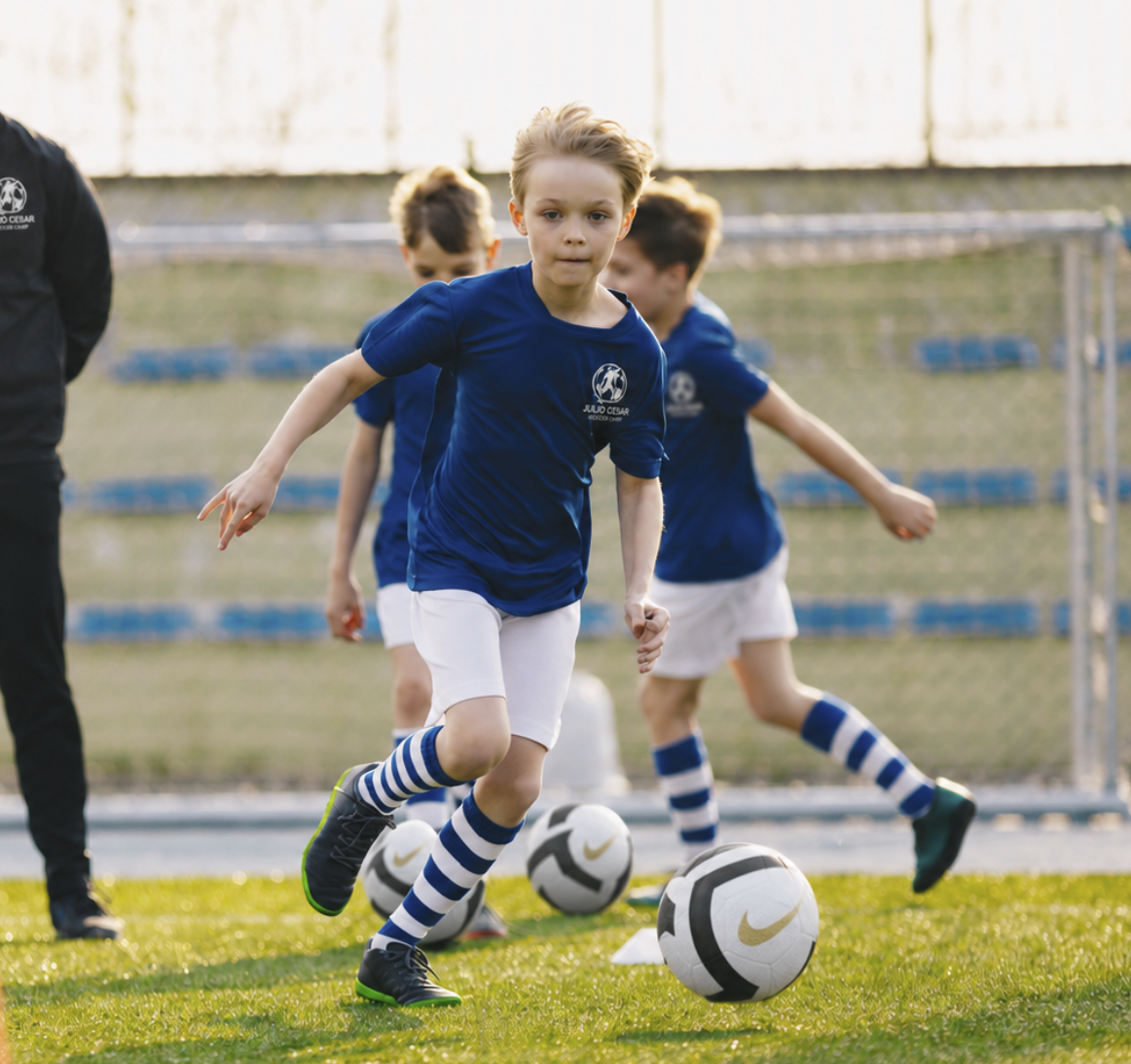 A young player driving at the ball in a camp session